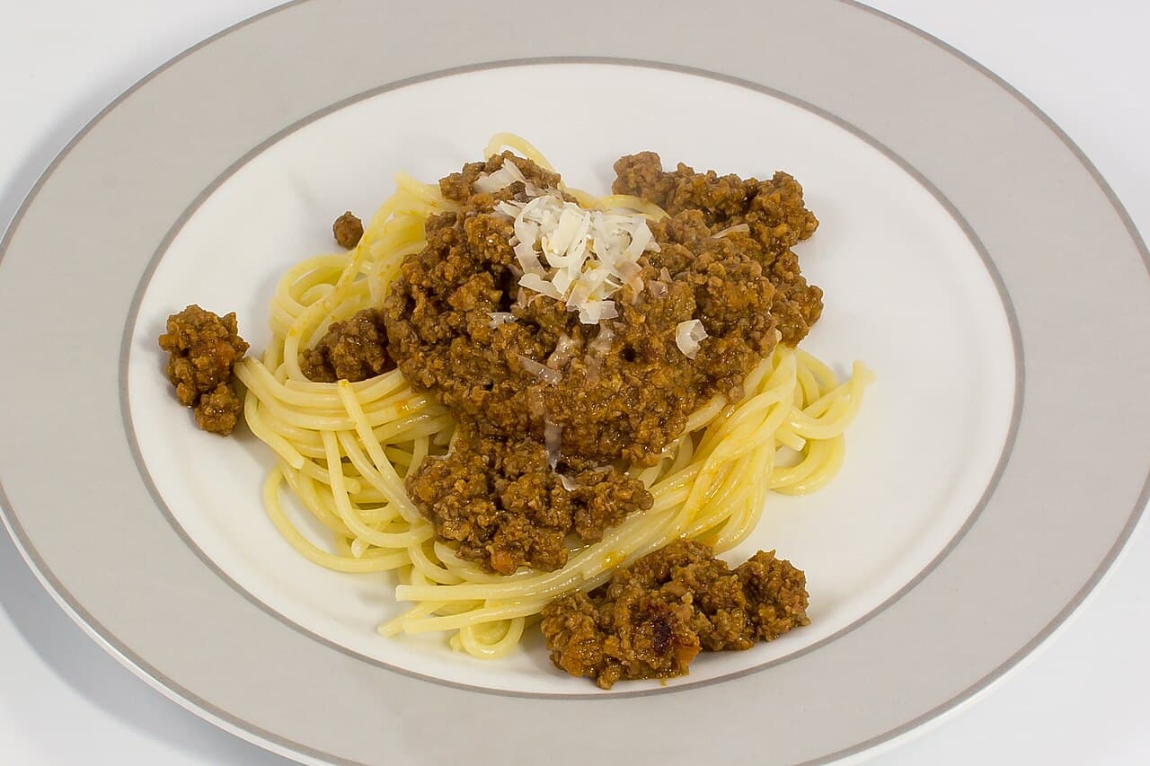 Spaghetti bolognese in a bowl topped with parmesan