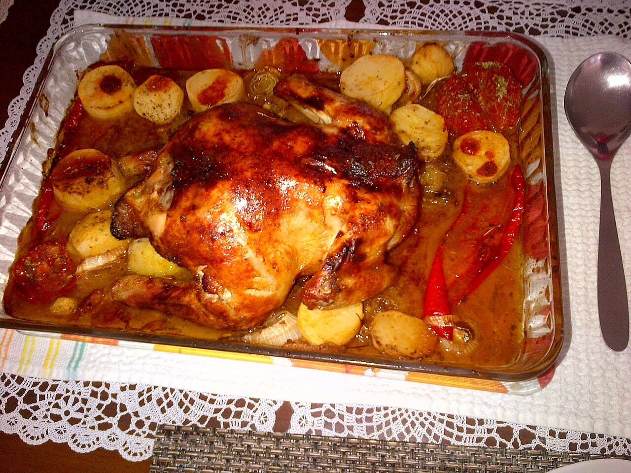Roasted chicken thighs with potatoes and lemon on a baking tray