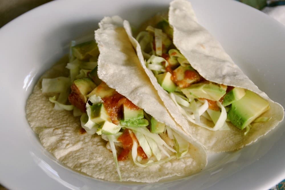 Fish tacos with slaw and lime on soft tortillas