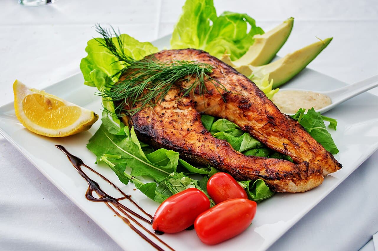Crispy skin salmon fillet on a bed of green vegetables