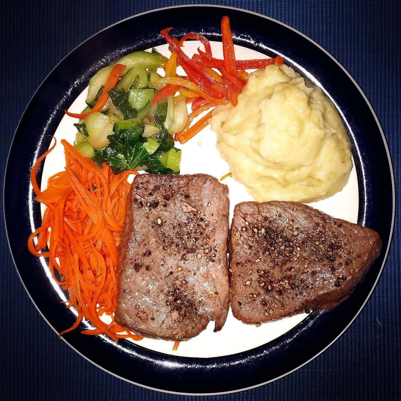 Sliced medium-rare steak resting on a mound of creamy mashed potato